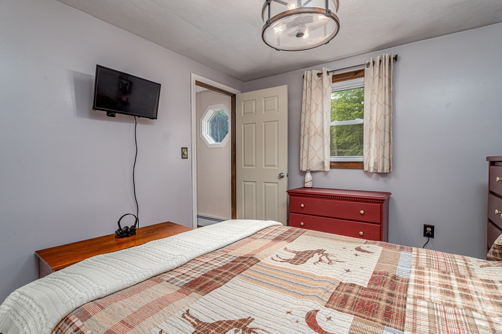 70 Valley Road Lunenburg, MA 01462 - Photo 12 of 42 a bedroom with a bed and a flat tv screen on the dresser