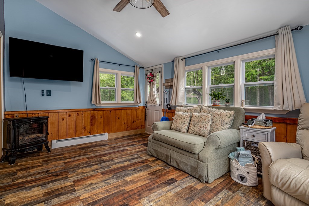 70 Valley Road Lunenburg, MA 01462 - Photo 17 of 42 a living room with furniture a flat screen tv and a floor to ceiling window