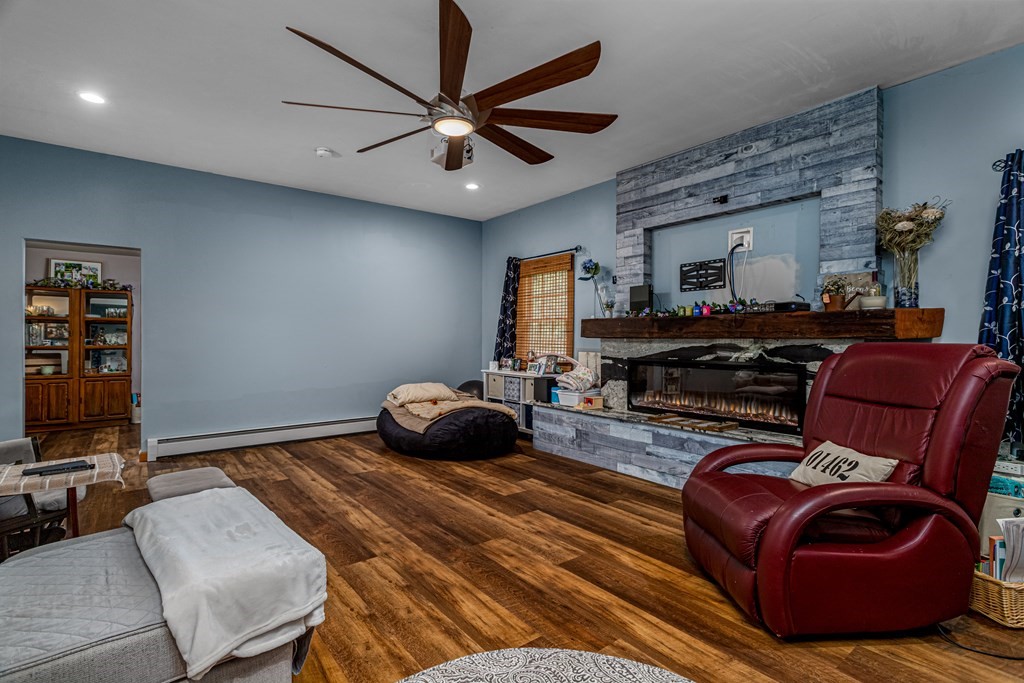 70 Valley Road Lunenburg, MA 01462 - Photo 26 of 42 a living room with furniture a ceiling fan and a flat screen tv