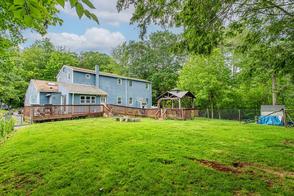 70 Valley Road Lunenburg, MA 01462 - Photo 39 of 42 a house that is sitting in the grass with large trees and plants