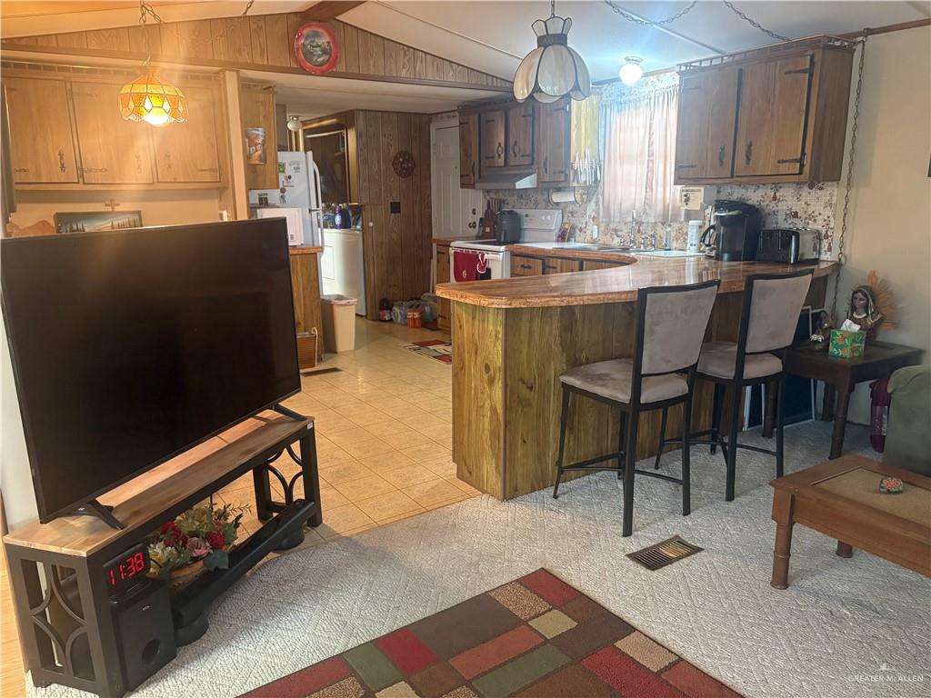 197 Laurel Road Pharr, TX 78577 - Photo 16 of 38 a kitchen with kitchen island granite countertop a table chairs sink and cabinets