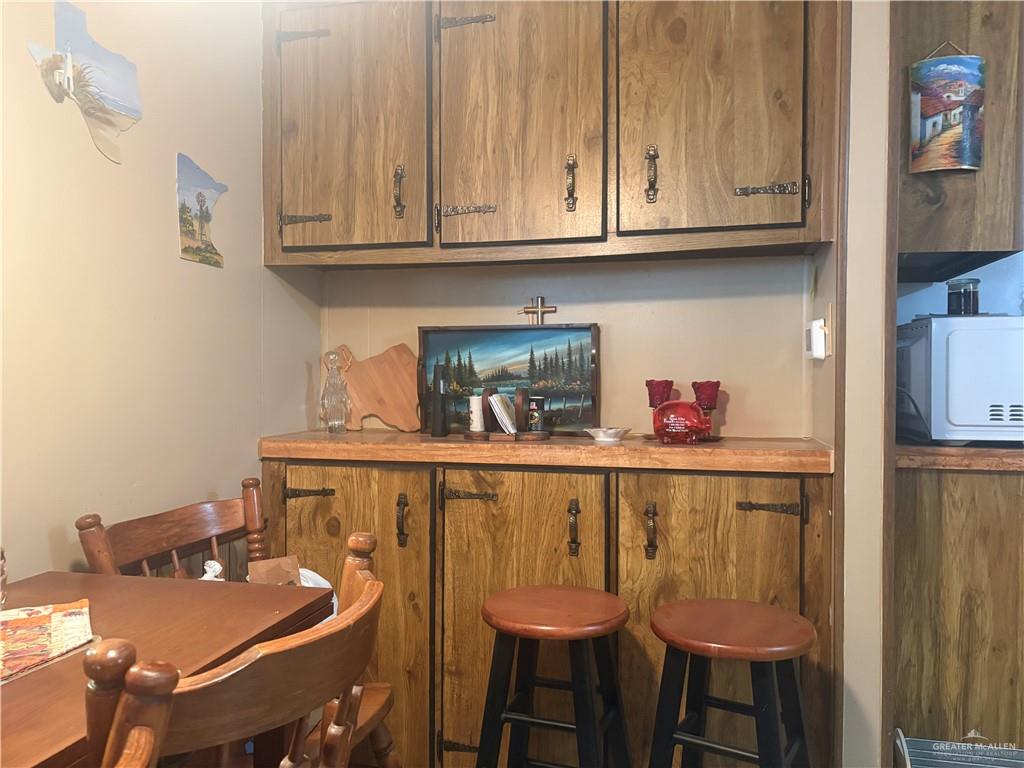 197 Laurel Road Pharr, TX 78577 - Photo 20 of 38 a kitchen with stainless steel appliances granite countertop a table chairs in it and wooden floors