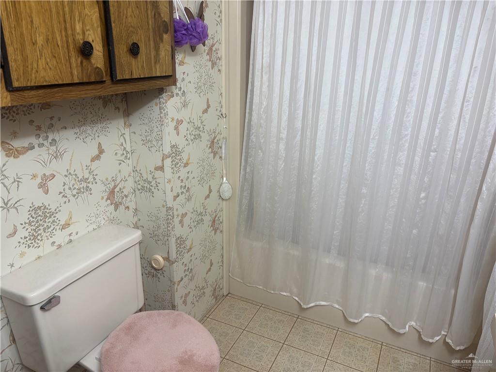 197 Laurel Road Pharr, TX 78577 - Photo 31 of 38 a bathroom with a toilet and a shower curtain