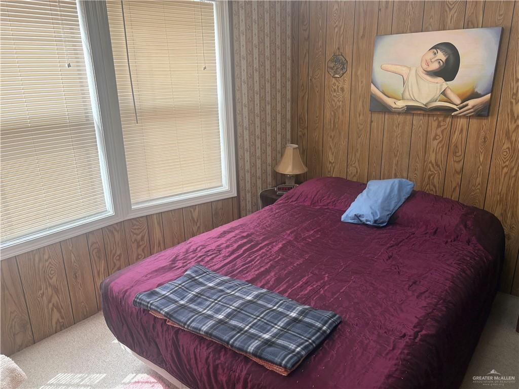 197 Laurel Road Pharr, TX 78577 - Photo 32 of 38 a bed sitting in a bedroom next to a window and a chandelier