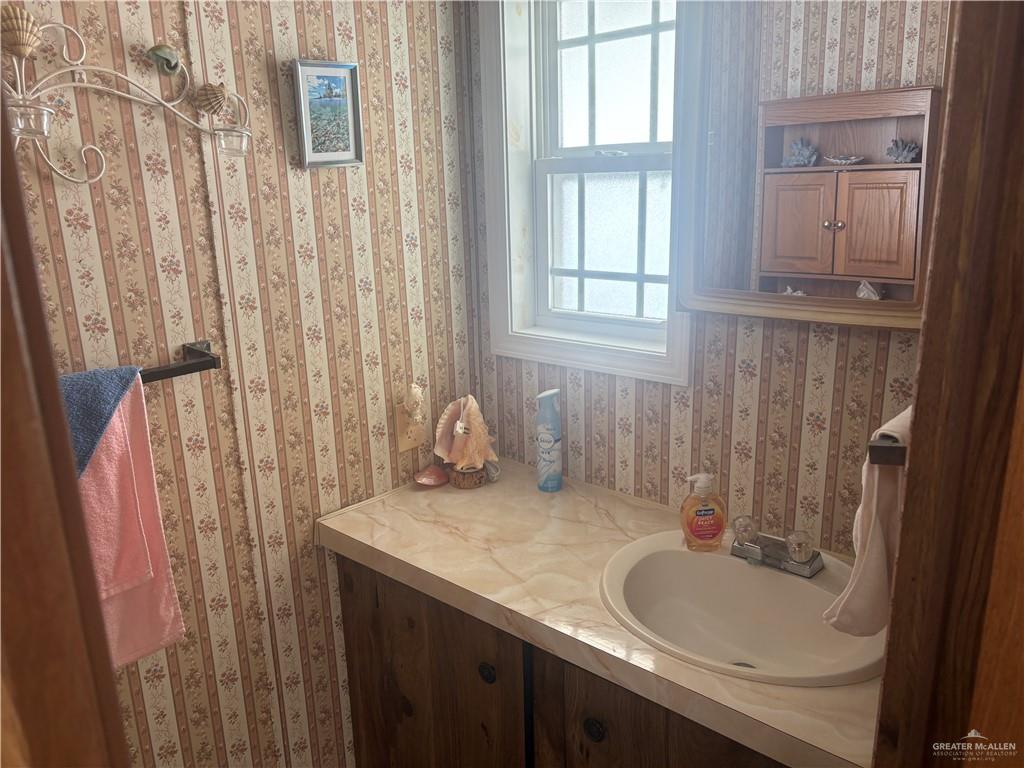 197 Laurel Road Pharr, TX 78577 - Photo 35 of 38 a bathroom with a granite countertop sink and a mirror