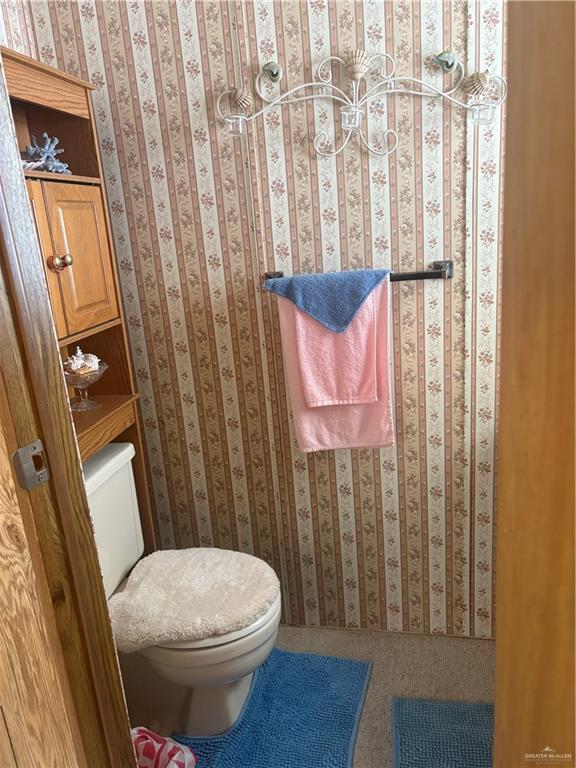 197 Laurel Road Pharr, TX 78577 - Photo 36 of 38 a white toilet sitting next to a shower curtain