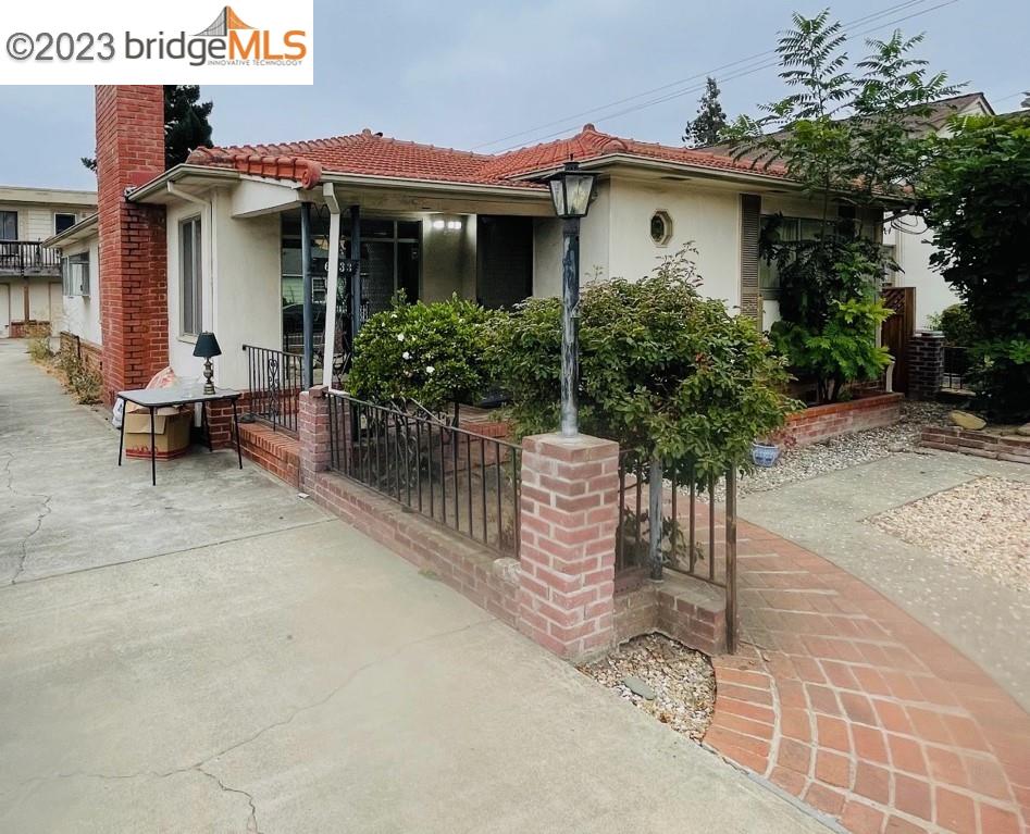 a view of a house with wooden fence and potted plants