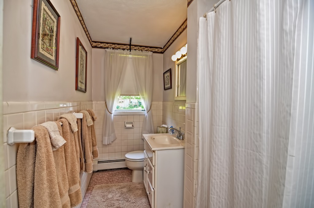 13 Sunnyvale Street Beverly, MA 01915 - Photo 24 of 25 a bathroom with a sink a toilet and shower curtain