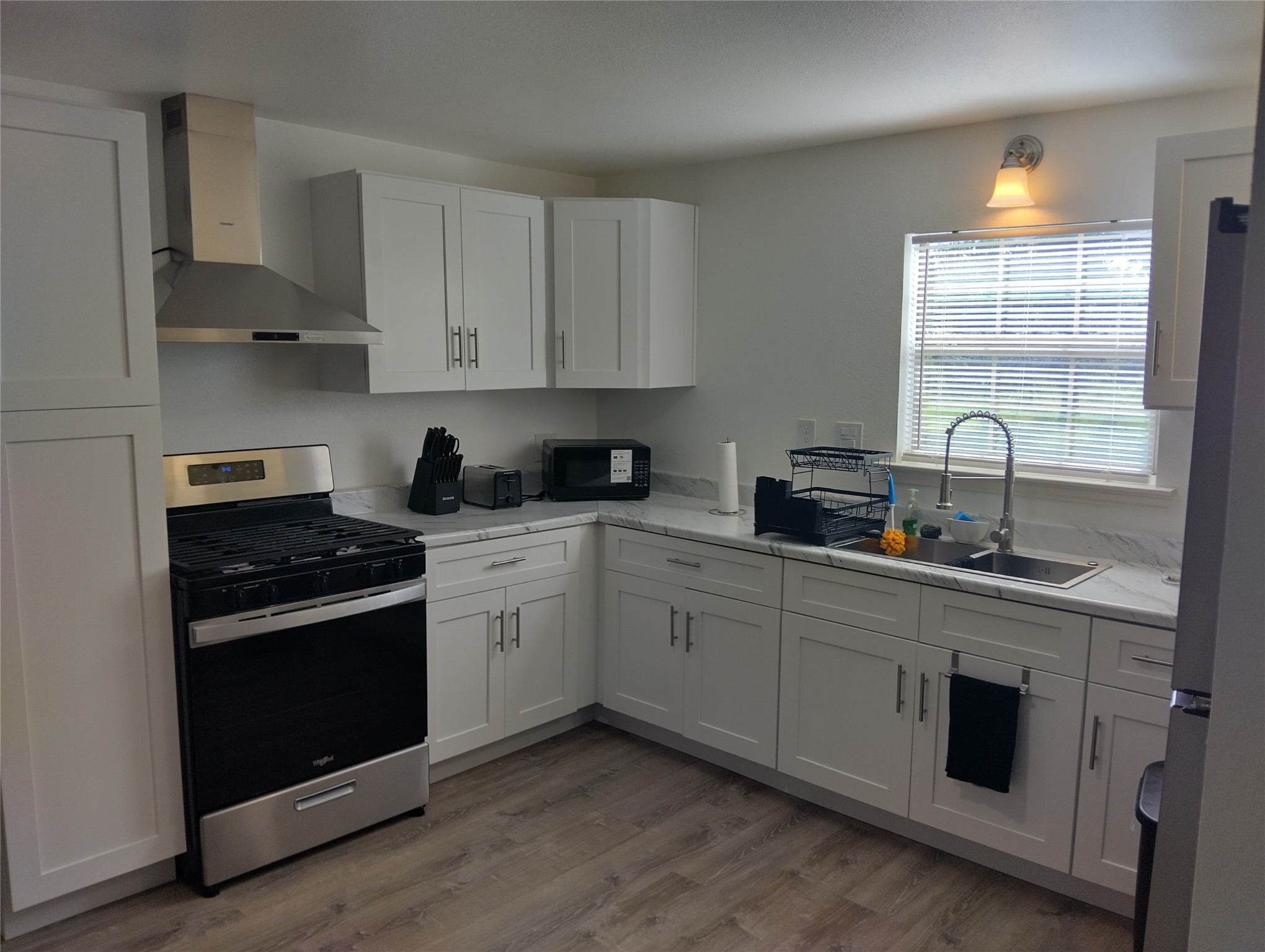 260 County Road 360 Splendora, TX 77372 - Photo 12 of 15 a kitchen with cabinets stainless steel appliances a sink and a window