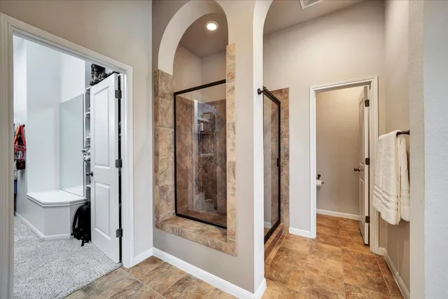 a bathroom with a glass door shower and a sink