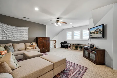 a living room with furniture ceiling fan and a window