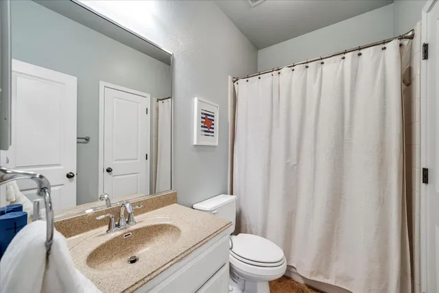a bathroom with a sink a toilet and shower curtain