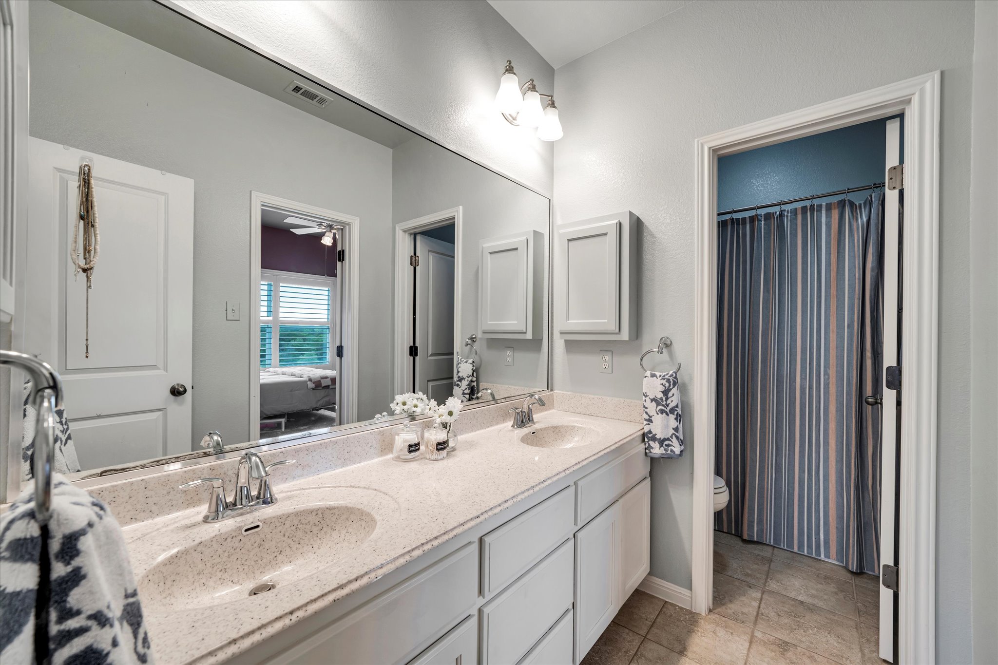440 Currie Ranch Road Wimberley, TX 78676 - Photo 26 of 40 a bathroom with double vanity sinks and a mirror