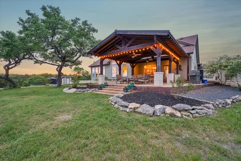 a backyard of a house with table and chairs