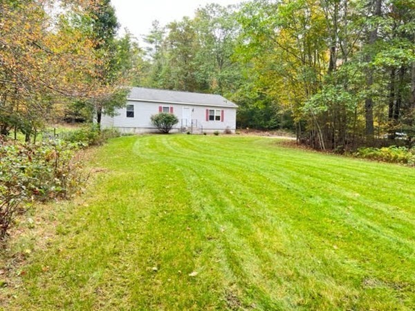 a front view of a house with a yard and trees