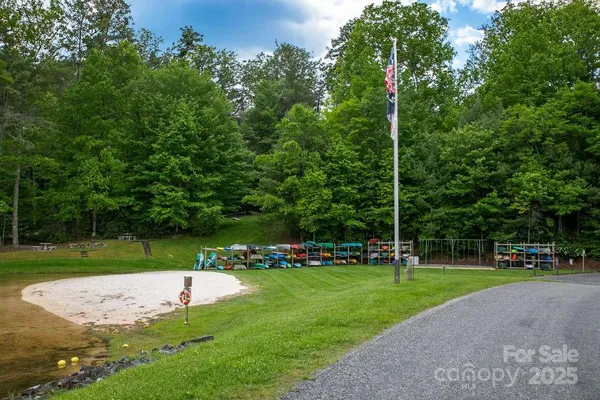 a view of a lush green outdoor space with a swimming pool and valleys in the background