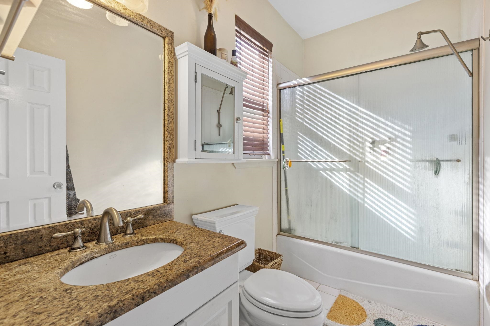 67 Highway 5 Edgewater, NJ 07020 - Photo 22 of 23 a bathroom with a granite countertop sink toilet a mirror and shower