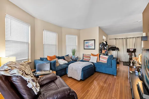 a bedroom with two beds and a large mirror next to a window