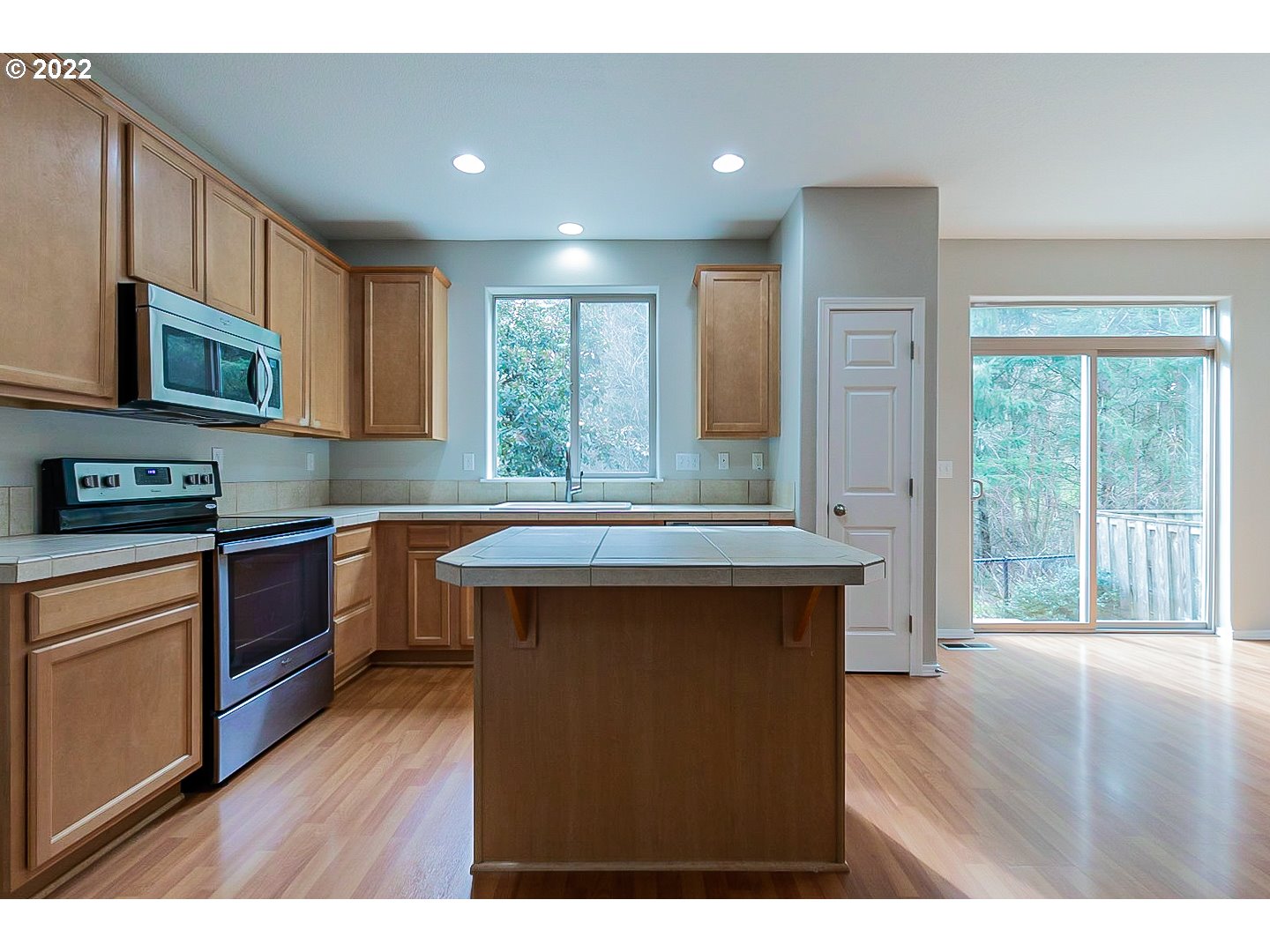 20008 Southwest Jette Lane Beaverton, OR 97003 - Photo 4 of 32 a kitchen with stainless steel appliances granite countertop a stove a sink dishwasher and a microwave oven with wooden floor