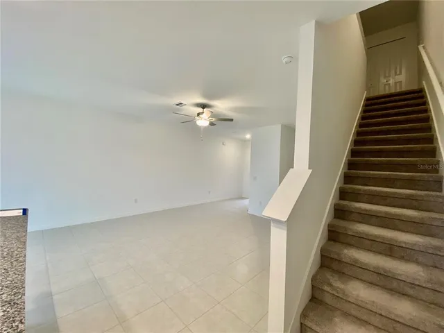 a view of an empty room with a ceiling fan