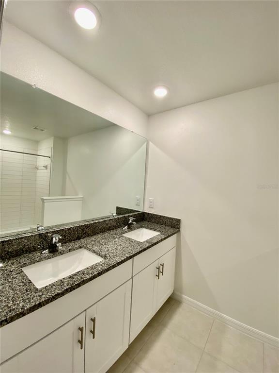 10373 Lavender Aster Trail San Antonio, FL 33576 - Photo 23 of 34 a bathroom with a granite countertop sink and a mirror