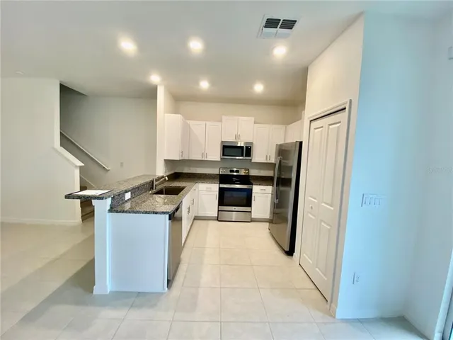 a kitchen with stainless steel appliances granite countertop a stove and a sink