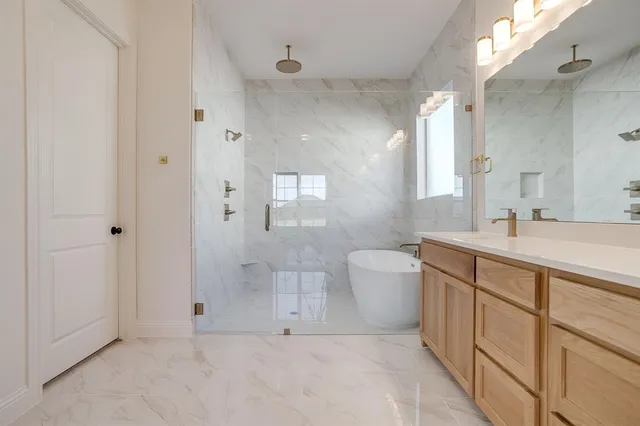 a spacious bathroom with a bathtub sink mirror and toilet