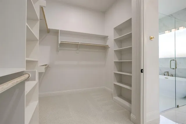 a view of walk in closet with empty racks
