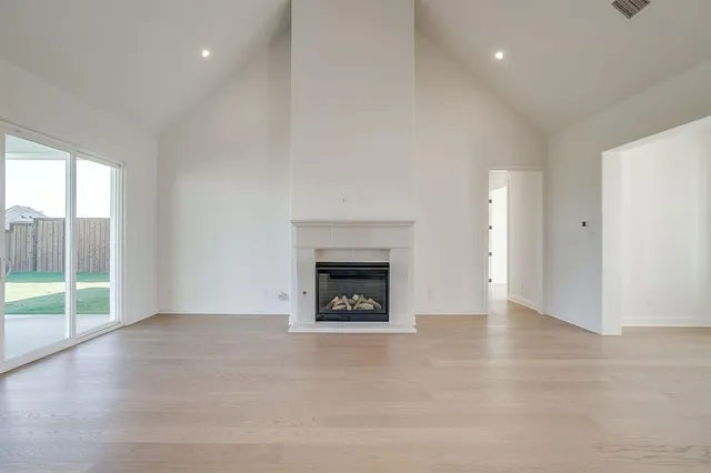 an empty room with floor to ceiling window and fireplace