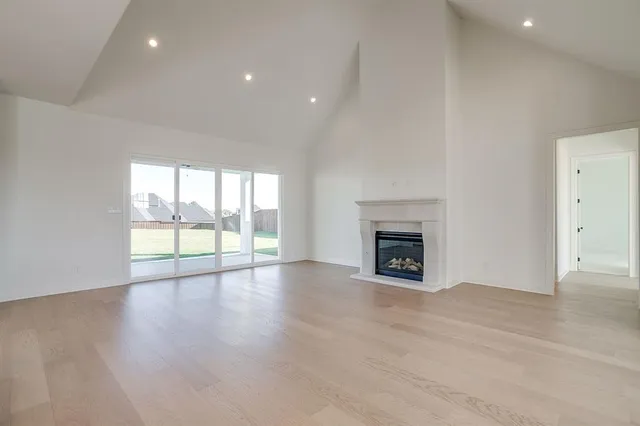 a view of an empty room with a window and fireplace