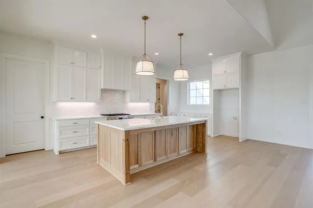 a kitchen with stove and wooden floor