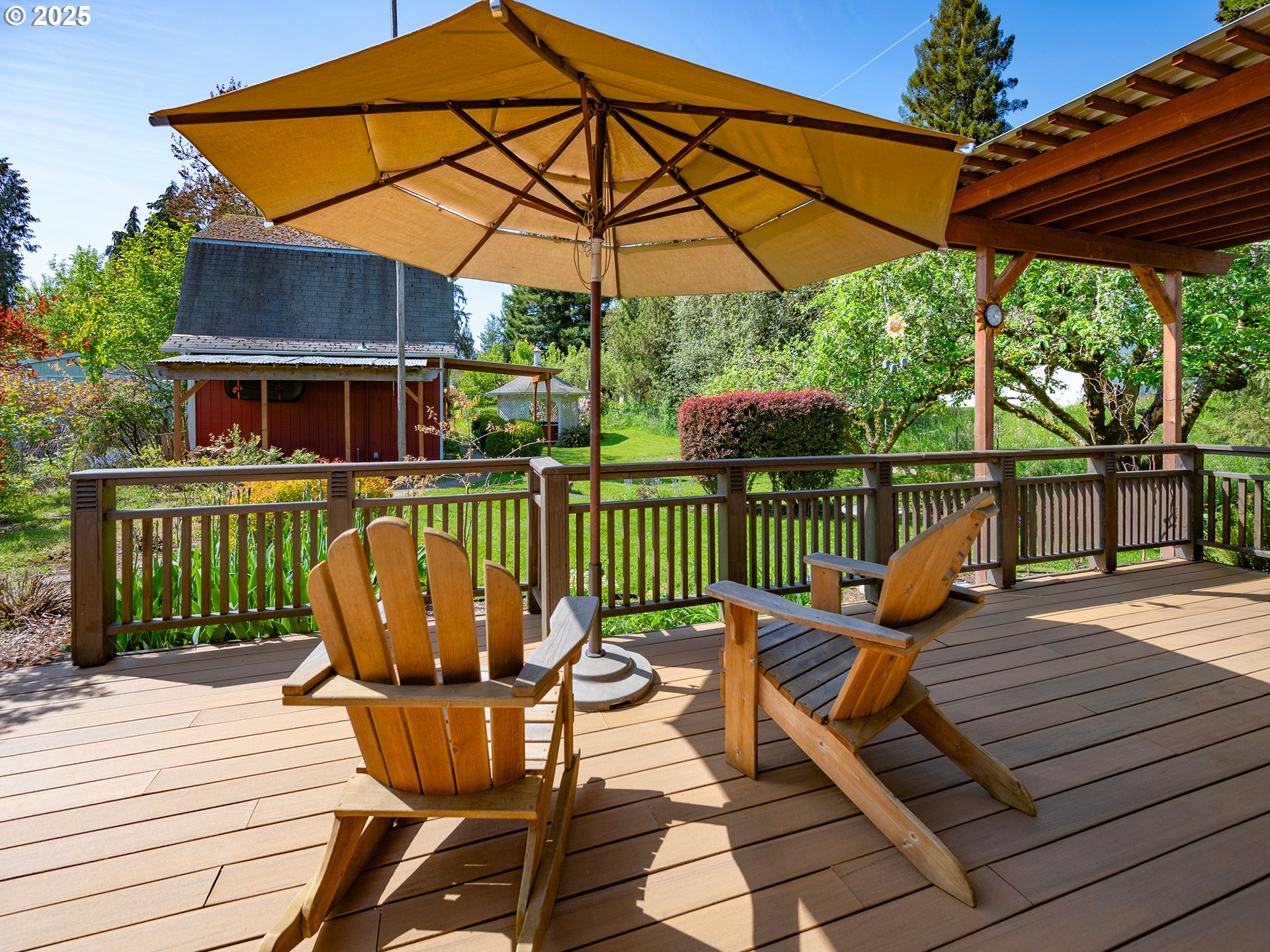 464 Spring Creek Drive Eugene, OR 97404 - Photo 19 of 45 a view of a roof deck with table and chairs under an umbrella with wooden floor and fence