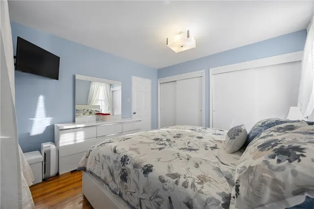 a spacious bedroom with a bed and a flat screen tv