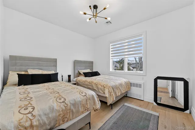 a bedroom with two beds and wooden floor