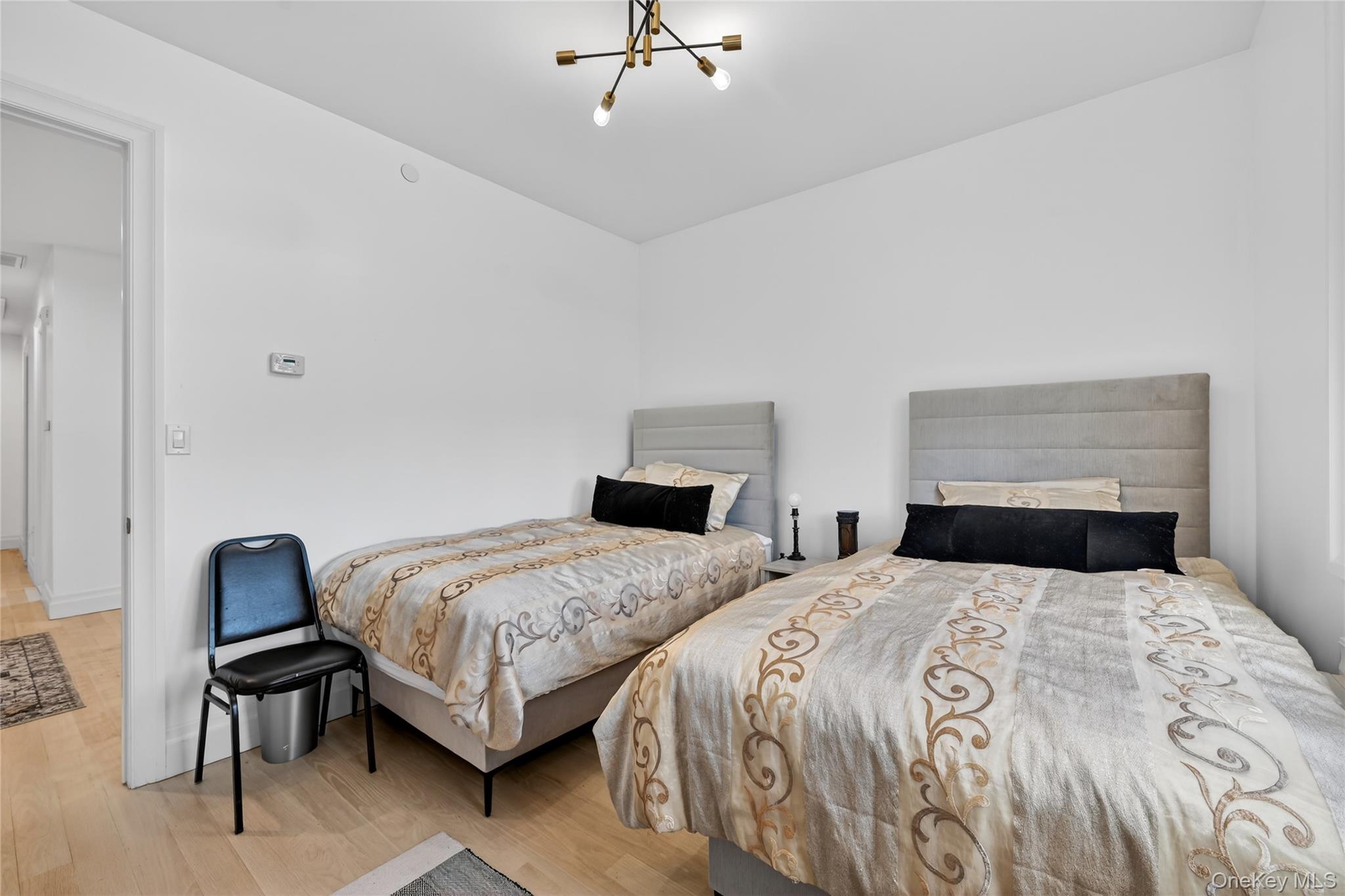 27 Ellish Parkway, Unit 202 Spring Valley, NY 10977 - Photo 27 of 50 a bedroom with two beds and a chair