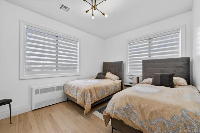 a bedroom with two beds and a chair