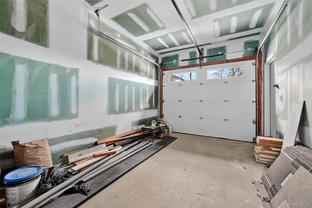 a view of a white house with large windows next to a road