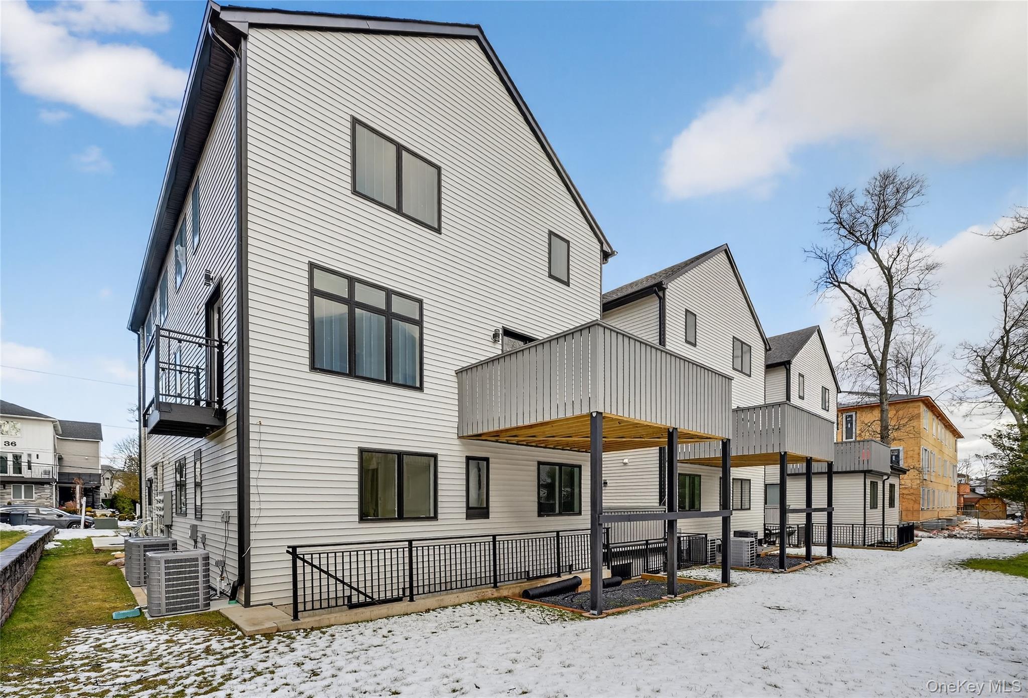 27 Ellish Parkway, Unit 202 Spring Valley, NY 10977 - Photo 50 of 50 a view of a white house with large windows next to a road