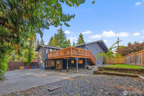 a view of a big house with a big yard and large trees