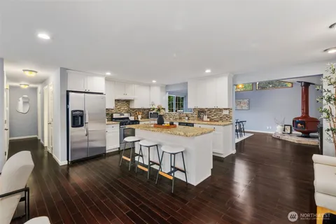 a large white kitchen with lots of counter space dining table and chairs