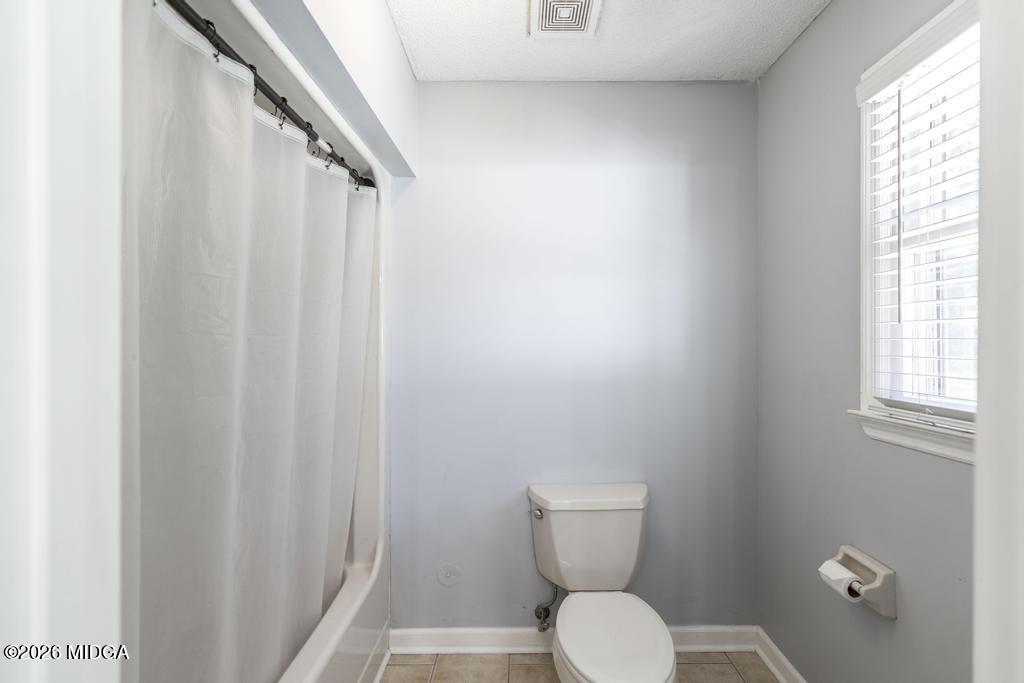 3710 Sandy Circle Macon, GA 31216 - Photo 19 of 44 a white toilet sitting next to a shower curtain