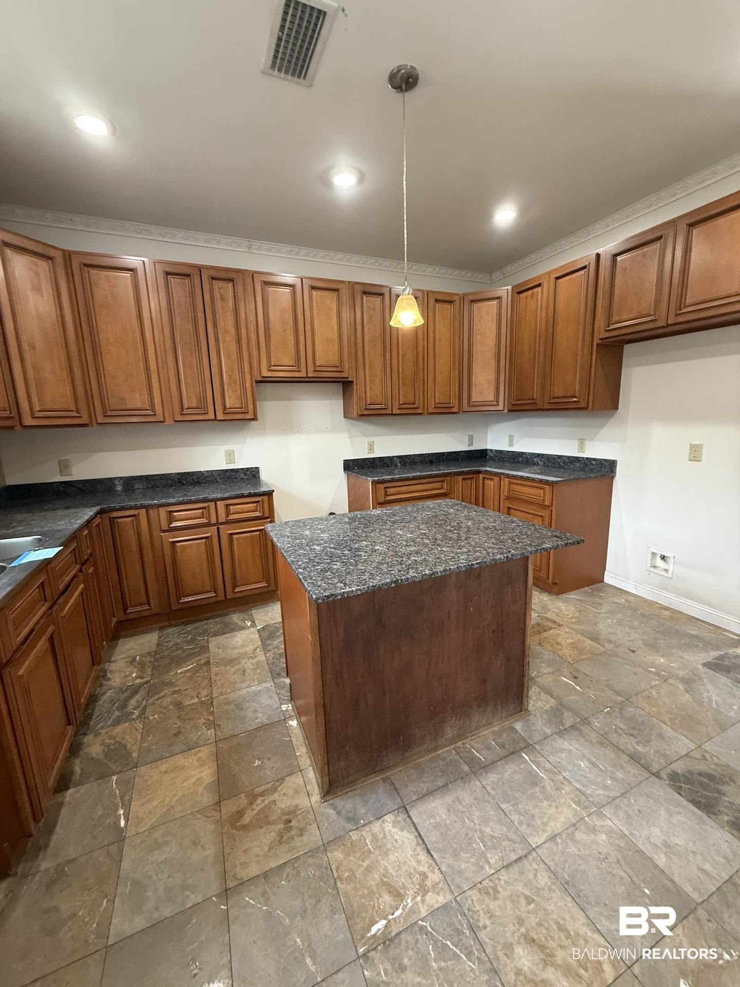 99 Cemetery Street Uriah, AL 36480 - Photo 2 of 13 Kitchen with wood finish cabinetry, dark stone finish floors, a center island, pendant lighting, and crown molding
