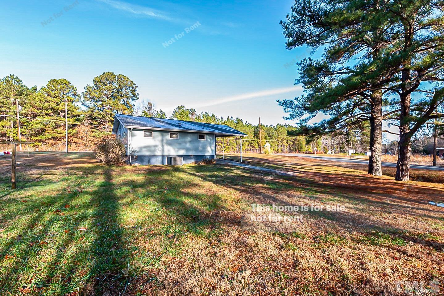 6108 Cheek Road Durham, NC 27704 - Photo 14 of 14 a view of a house with a big yard and large trees