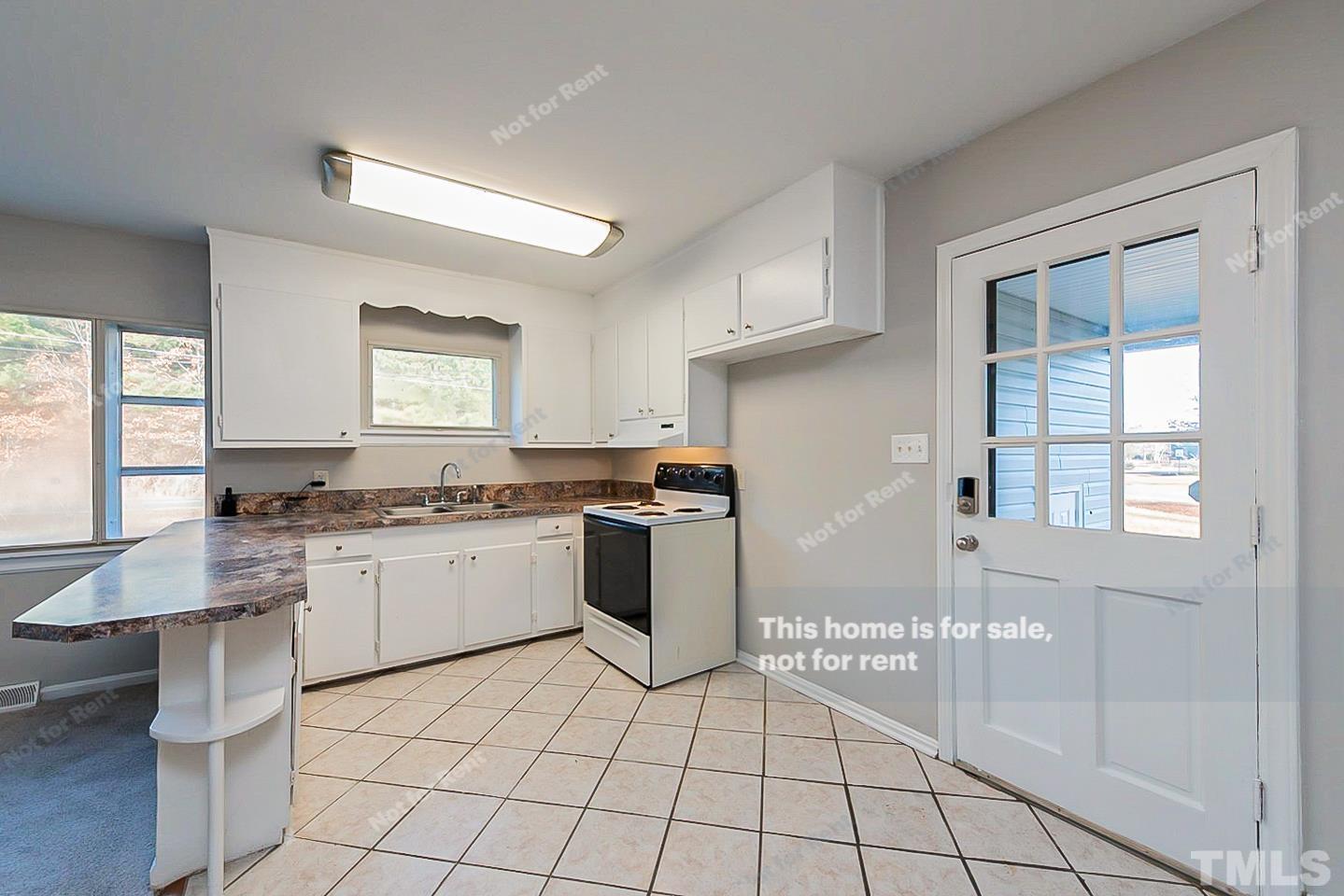 6108 Cheek Road Durham, NC 27704 - Photo 4 of 14 a kitchen with a sink a counter top space and appliances