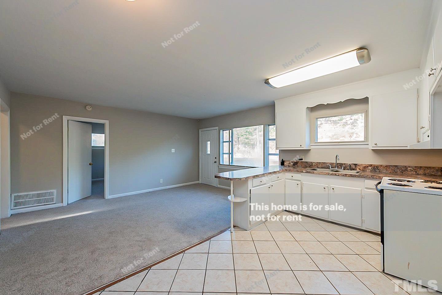 6108 Cheek Road Durham, NC 27704 - Photo 8 of 14 a large kitchen with granite countertop a stove a sink dishwasher and a refrigerator