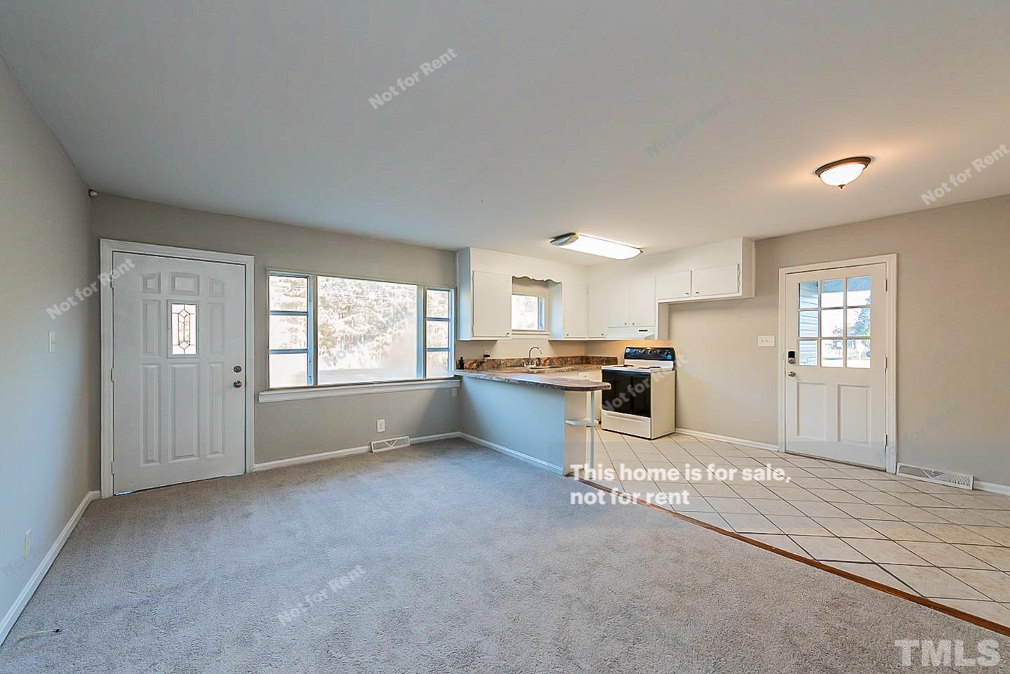 6108 Cheek Road Durham, NC 27704 - Photo 9 of 14 a large white kitchen with a refrigerator a stove a sink and a cabinets