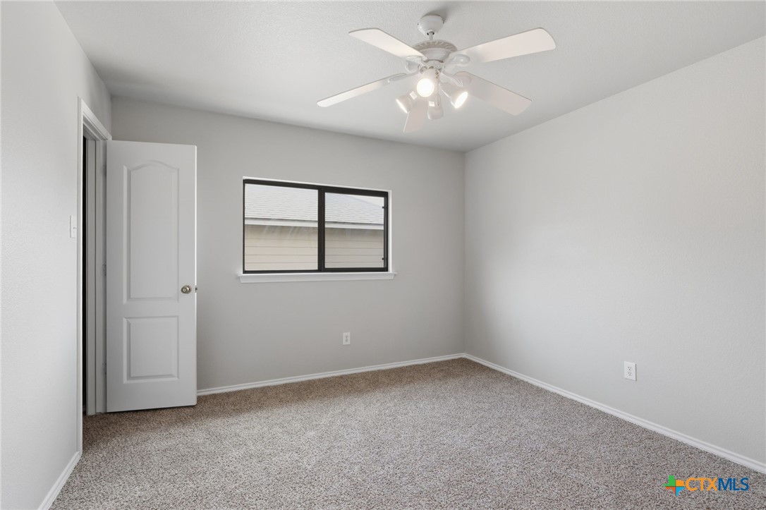 8716 Starview Street Temple, TX 76502 - Photo 25 of 36 Anther bedroom complete with a ceiling fan, window and neutral tones.