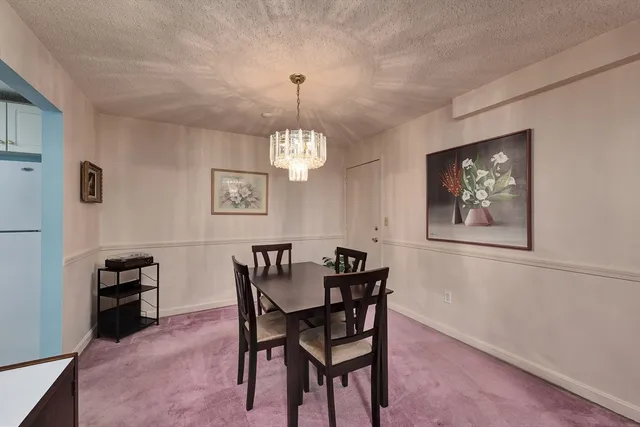 a view of a dining room with furniture and chandelier