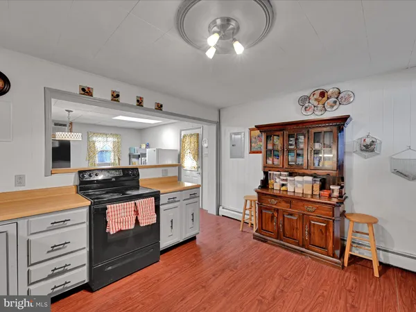 a kitchen with granite countertop a refrigerator a sink and wooden floors