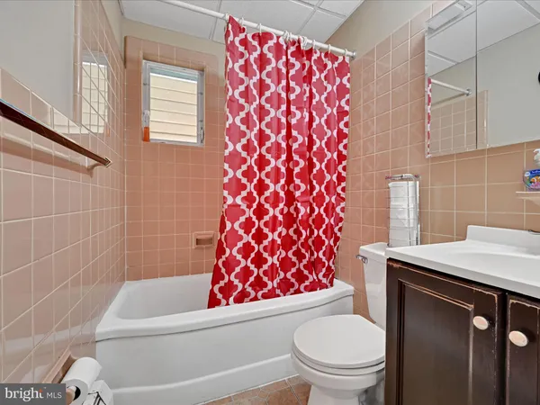 a bedroom with a bed and a lamp on dresser